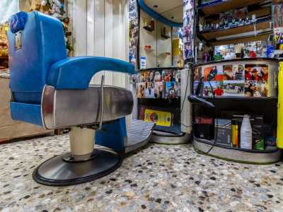 Ci ricordiamo di essere in una sala da barbiere solo per la solitaria poltrona celeste in ferro tipica delle attivit� �vecchio stampo�...